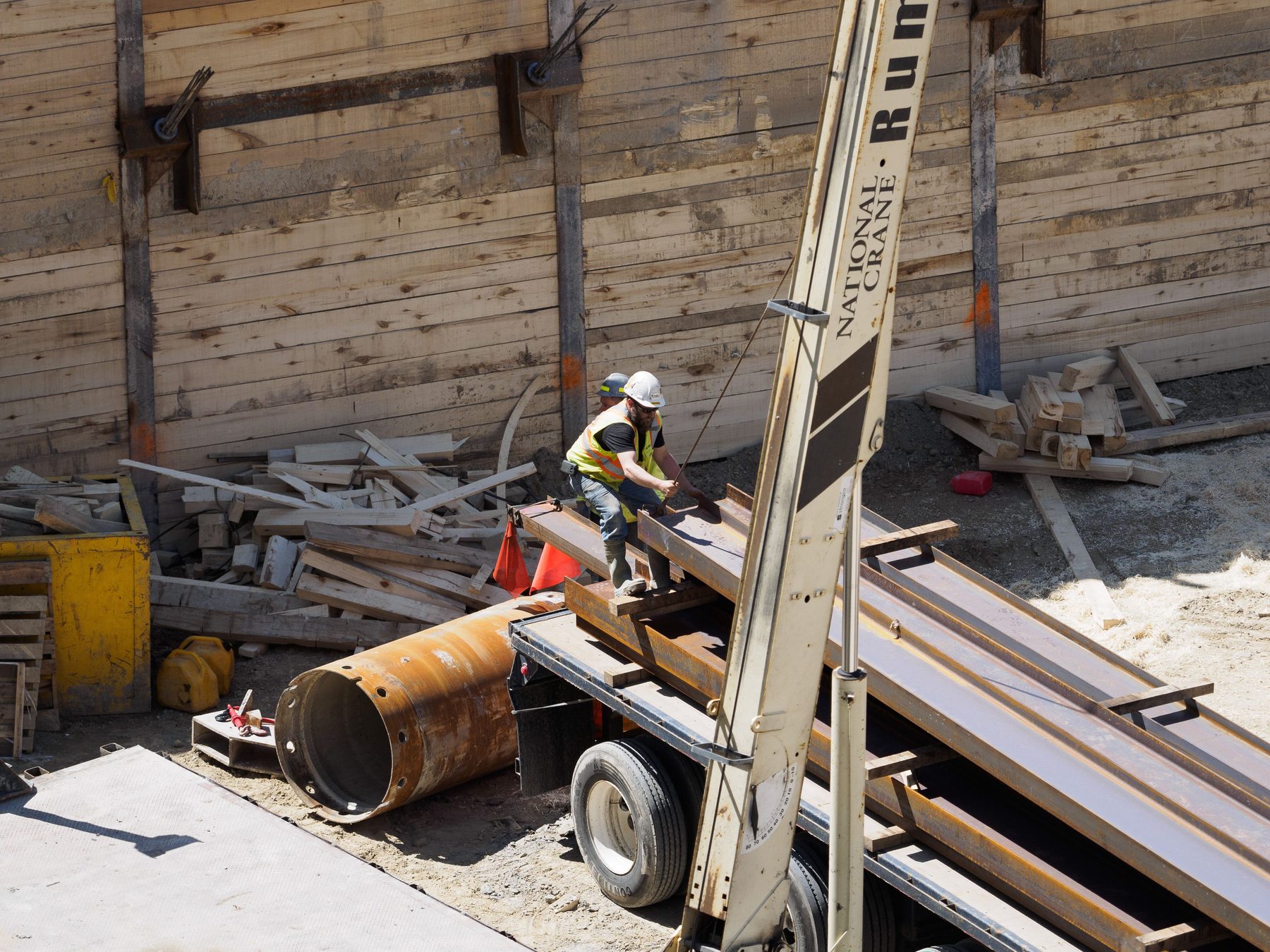 Construction workers handling structural steel beams